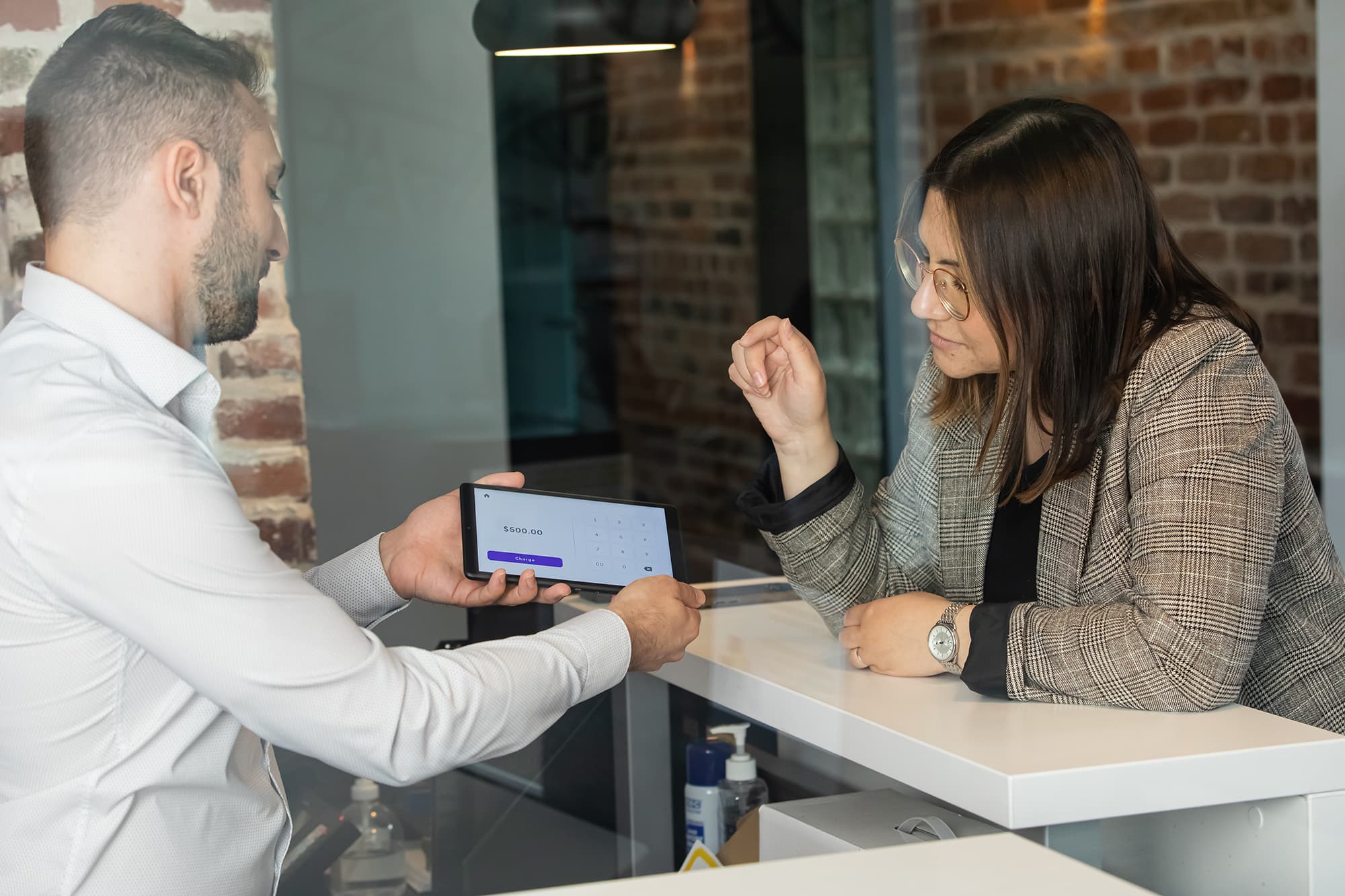 Person explaining to a client how to use the tablet.