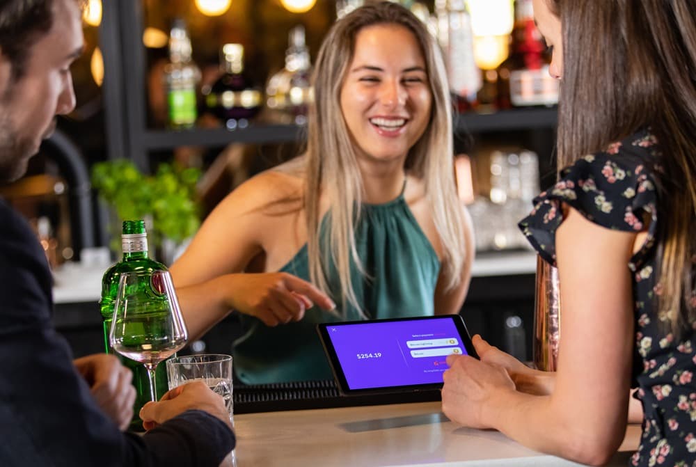 Personne au bar payant avec l'application Dello.
